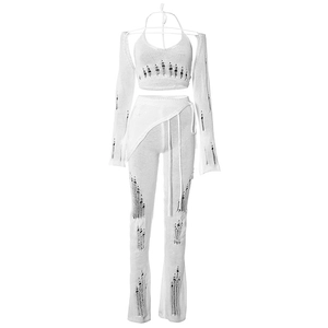Detail of white knit four-piece set with distressed cut-outs and flared pant silhouette