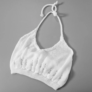 Detail of white knit halter top featuring distressed vertical hollow-out patterns