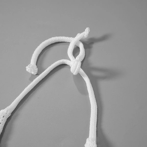 Detailed macro view of white knitted drawstring texture and knot detail for 4-piece set