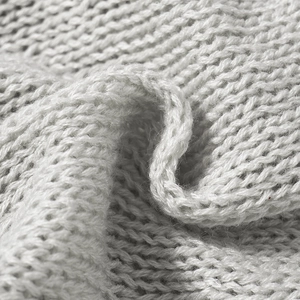 Gros plan macro d'un tissu en maille gris clair avec texture douce et motif à mailles plates