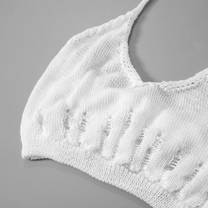 Detailed view of white knit crop top featuring distressed hem and hollow out texture