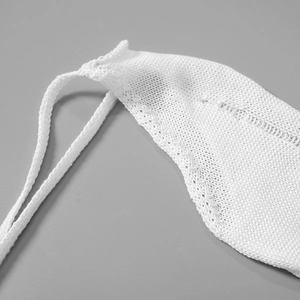 Detail of white crochet knit fabric with delicate drawstring cord and texture