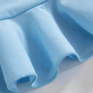 Détail du tissu plissé bleu clair montrant les coutures de qualité et l'ourlet volanté
