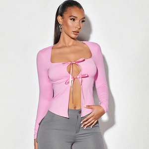 Détail du haut en maille rose avec encolure carrée et liens à nouer décoratifs
