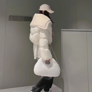 Detail shot of the plush faux fur collar and solid white quilted puffer coat for women
