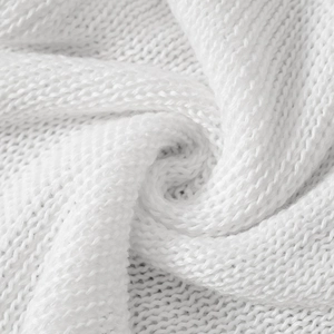 Macro view of white knitted fabric detail showing fine texture and soft spiral folds
