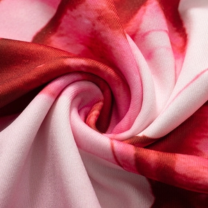 Detailweergave van zachte gebreide stof met rode en roze bloemen digitale print