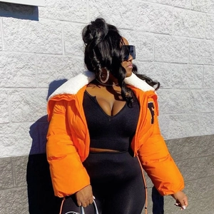 Detail of orange puffer jacket featuring a white faux shearling collar and letter embroidery