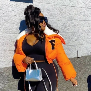Detail of orange puffer jacket with white faux fur collar and black letter F embroidery