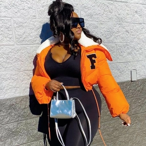 Detail of bright orange puffer jacket with faux fur collar and F letter patch