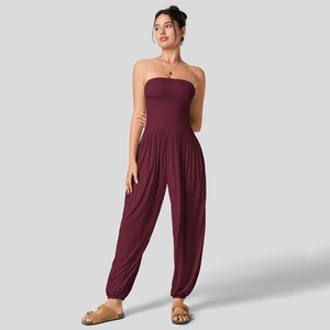 Detailweergave van bordeauxrode strapless jumpsuit met taille en geplooide lantaarnbroek