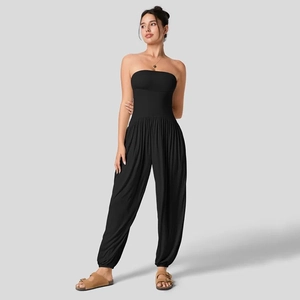 Detail van een zwarte strapless jumpsuit met getailleerde taille en wijde harembroek