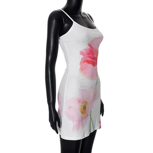 Detailweergave van een witte mini-jurk met grote roze bloemenprint op gebreide stof