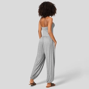 Detailaanzicht achterkant van een lichtgrijze strapless jumpsuit met geplooide taille en boorden