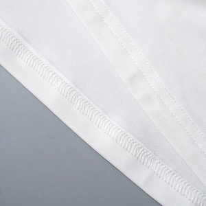 Macro detail of the white sleeveless dress showing fine twill fabric and reinforced stitching