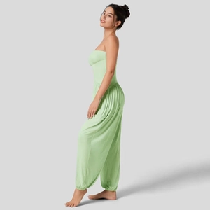 Detail van lichtgroene strapless jumpsuit met gesmokte taille en elastische enkelmanchetten