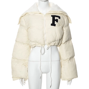 Detail of cream puff jacket featuring fuzzy letter F patch and white faux fur collar
