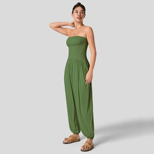 Detail van olijfgroene strapless jumpsuit met getailleerde taille en wijde harembroek