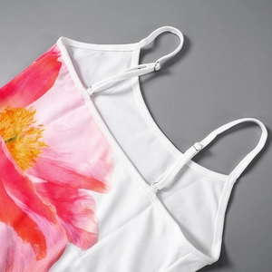 Detailopname van verstelbare spaghettibandjes en bloemenprint op een witte jurk