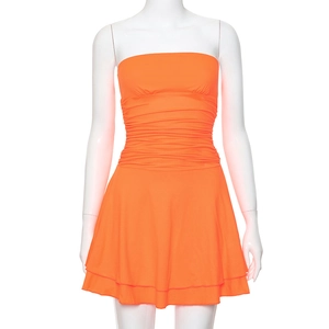 Detailed view of bright orange strapless dress featuring elegant ruching and layered hem