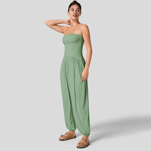 Detail van grasgroene strapless jumpsuit met elastische manchetten en zachte stoftextuur