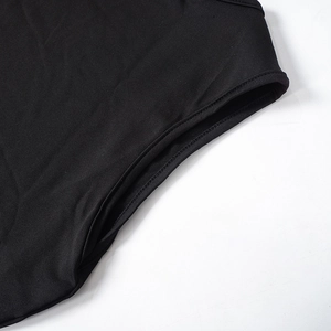 Detailed close-up of double-needle stitching and hem finish on the black sleeveless dress