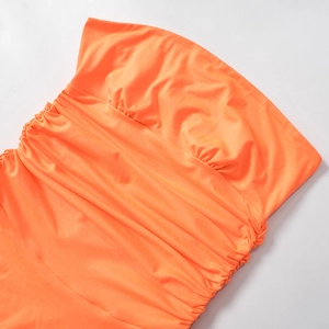 Detail of bright orange ruched fabric with elegant pleated texture on a strapless dress