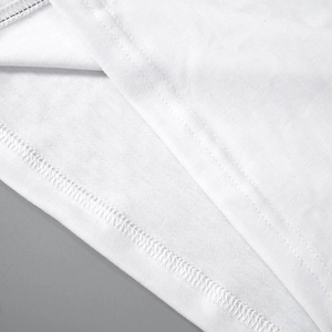 Detail of high-quality double-needle stitching and overlock seams on white cotton dress