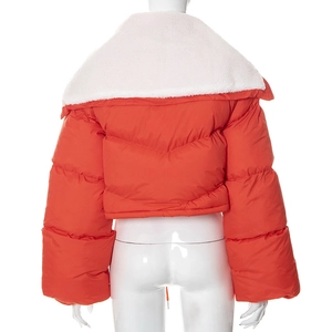 Detail view of the orange puffer jacket featuring a contrast white faux shearling collar
