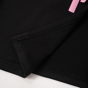 Gros plan sur tissu en maille noir avec ruban rose et ourlet à double couture