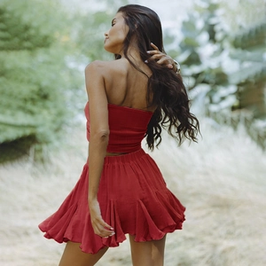 Detail view of red two-piece resort set featuring strapless top and ruffled mini skirt