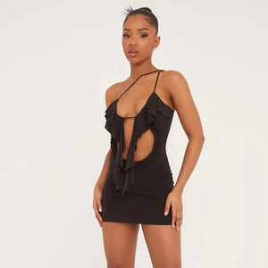 Détail de la robe moulante noire avec buste à volants et découpes à la taille