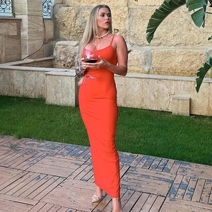 Detail view of a slim-fit orange maxi dress with thin straps and a side split design