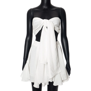 Detailed view of white strapless top with oversized bow and layered ruffle mini skirt set