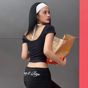Detail of female sports set showing backless crop top and Beauty & Rage print leggings