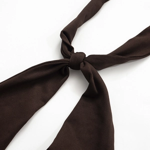 Gros plan détaillé du lien en tissu tricoté marron foncé montrant la texture et le nœud