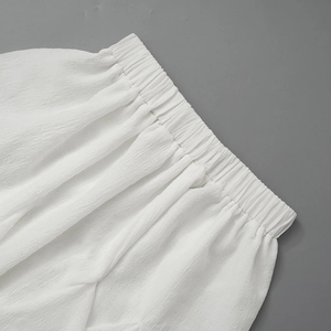 Detail of white pleated chiffon skirt with elastic waist and soft textured fabric