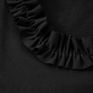 Détail rapproché des bords à volants noirs et de la texture côtelée d'une robe courte