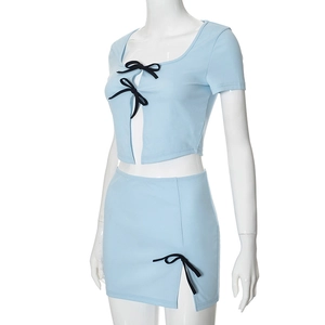 Detail van lichtblauw tweedelig setje met zwarte strikjes op crop top en rok met split