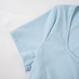 Detailopname van lichtblauwe gebreide crop top met U-hals en fijne stikseldetails