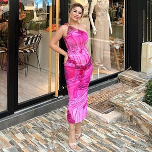 Dettaglio dell'abito con stampa marmo rosa con spalla asimmetrica e anello in oro