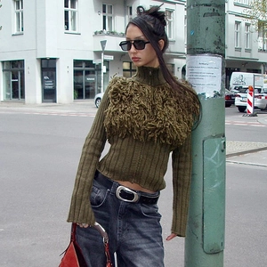 Detail of dark green ribbed knit cardigan featuring contrast faux fur chest paneling