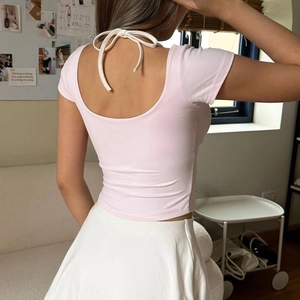 Close-up of pink slim fit open back t-shirt with white ribbon tie detail