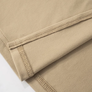 Detailed close-up showing the double-stitched hem and fine fabric texture on a khaki dress