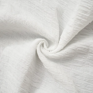 Detailed macro shot of white seersucker fabric texture with ruffled waffle pattern