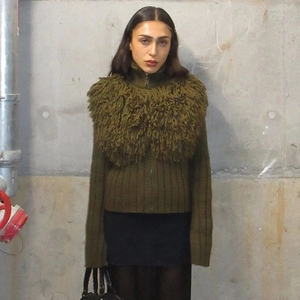 Detail of army green knit cardigan featuring a bold faux fur collar and zip closure