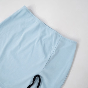 Detail van lichtblauwe katoenen stof met een contrasterend zwart lint op de taille