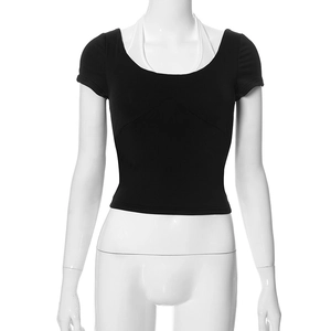 Detail of a slim fit black crop top with a white halter neck layered design and round neck