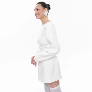 Detail of white mini dress featuring structured puff sleeves and fitted waist silhouette