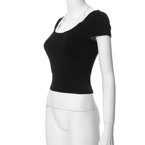 Detail of black cut-out t-shirt featuring a white halter neck strap and slim cropped fit